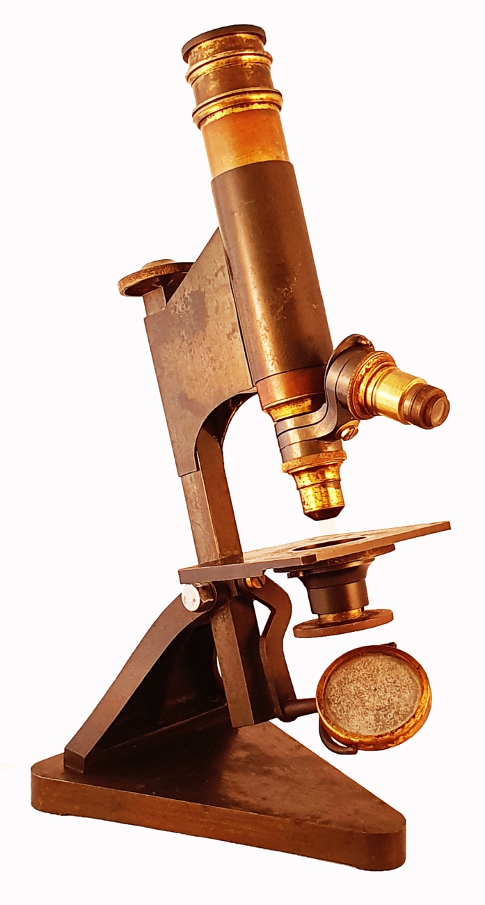 Microscope In 1900 A wooden tableDescription automatically generated